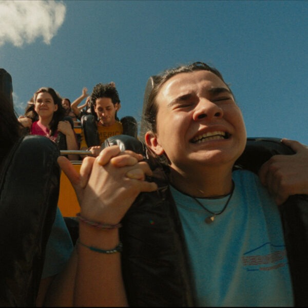 Two girls riding a roller coaster in blue shirts.