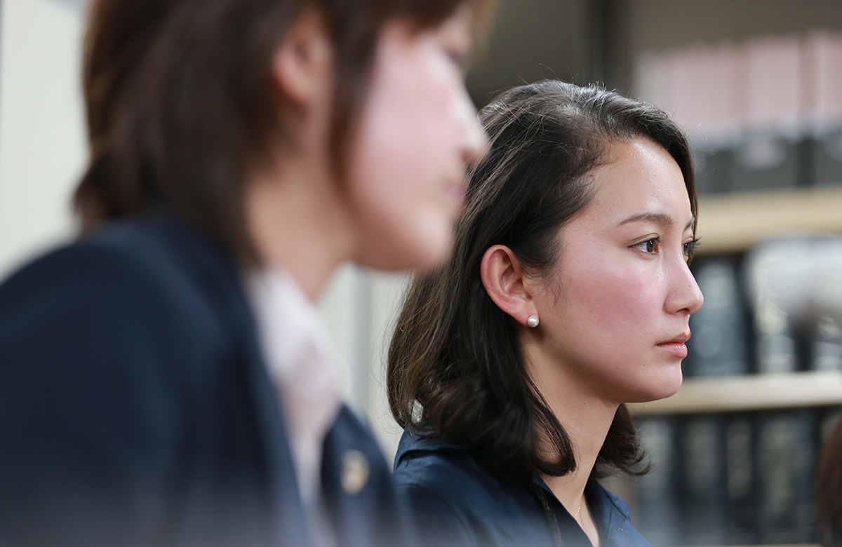 Two women sitting in a courtroom.
