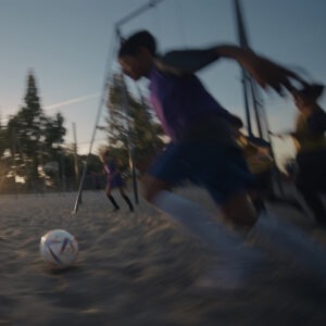 A boy running to kick a soccer ball.