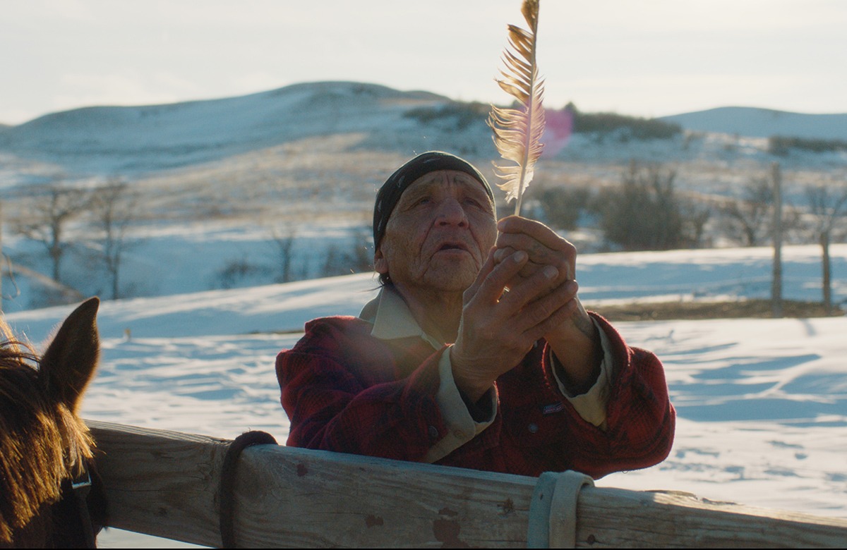 Woman in snow holding feather.