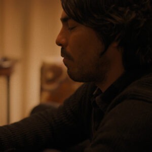 A man holding a glass bottle with a ship inside.