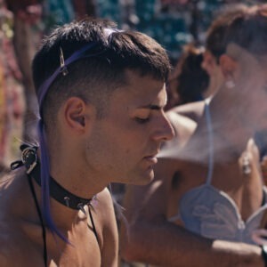A group of men smoking in front of a wall.
