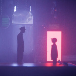 A man in a uniform looking at a little boy in a cap.